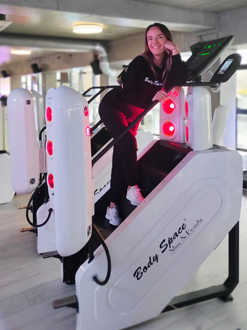 Uśmiechnięta kobieta na InfraRed Stepper Body Space® z czerwonym światłem podczerwonym